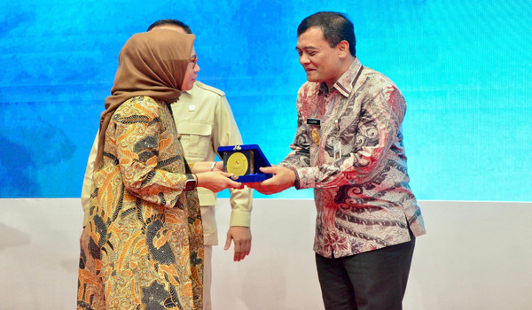 Menteri Pemberdayaan Aparatur Negara dan Reformasi Birokrasi (PAN-RB) Rini Widyantini bertukar cinderamata dengan Gubernur Jateng Ahmad Lutfi usai Rakor Bidang Kelembagaan dan Tata Laksana Pemerintah Daerah di Kota Semarang, Rabu (29/10). [Foto: Dok Humas]