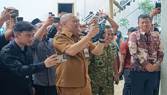 Gubernur Jawa Tengah Ahmad Luthfi dengan luwesnya mengabadikan Wakil Presiden RI Gibran Rakabuming Raka dan warga di lokasi tanah bergerak, Tegal, Jumat (6/2). [Foto: Dok humas]